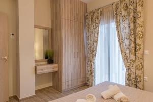 sypialnia z łóżkiem i dużym oknem w obiekcie Rose Villa with Private Pool w mieście Roúpai