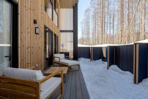 a building with snow on the floor and benches at Ginto Hirafu by H2 Life in Niseko