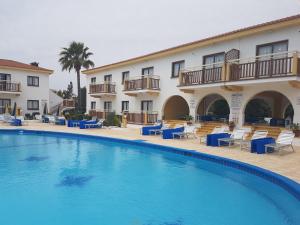 un hotel con piscina frente a un edificio en Cosmelenia Hotel Apartments en Ayia Napa