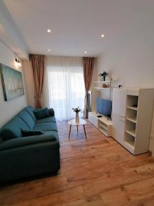 ein Wohnzimmer mit einem grünen Sofa und einem Tisch in der Unterkunft Corallium Imperiale in Goveđari