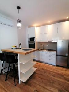 a kitchen with white cabinets and a wooden counter top at Corallium Imperiale in Goveđari