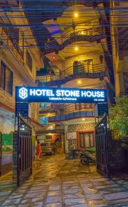 ein Steinhaus mit Schild in einem Gebäude in der Unterkunft Hotel Stone House in Pokhara