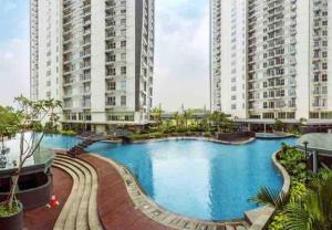ein großer Pool mit zwei hohen Gebäuden in der Unterkunft Montero- Casa De Parco Panoramic View Apartment in Tangerang
