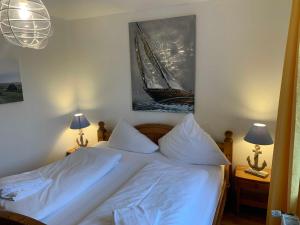um quarto com uma cama branca e uma fotografia na parede em Ferienwohnung Deichläufer em Nordstrand