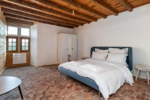a bedroom with a large bed and a table at Appartements au Château Ars in Ars-sur-Formans