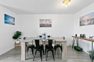 a dining room with a wooden table and chairs at Beachwood at Margate Beach in Redcliffe