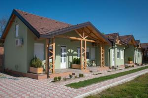una fila de casas verdes con techo de madera en Zlatni Klas en Zrenjanin