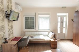 a room with a bed and a desk and a window at Zlatni Klas in Zrenjanin