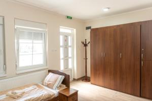a bedroom with a bed and a wooden cabinet at Zlatni Klas in Zrenjanin