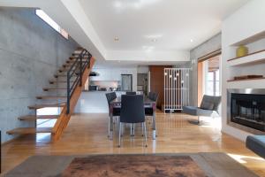 新雪谷的住宿－Yuki Ten by H2 Life，客厅设有餐桌和楼梯。