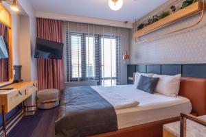a hotel room with a bed and a television at Viva La Vita Butik Otel in Izmir