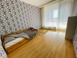 a bedroom with a bed in the corner of a room at Jaunā Teika Penthouse in Riga