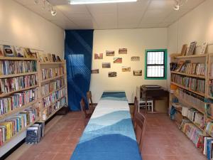 a library with a long table and shelves of books at Wanluan Organic Bookstore in Wanluan