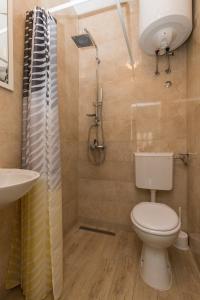 y baño con aseo, lavabo y ducha. en Guest House Bradas, en Dubrovnik