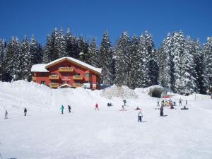 a group of people in the snow in front of a ski lodge at Hotel Casa del Campo in Madonna di Campiglio