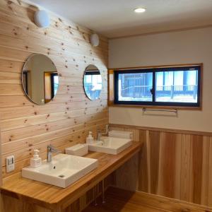 a bathroom with two sinks and a mirror at GOKAYAMA BASE in Nanto