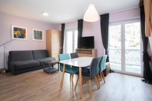 ein Wohnzimmer mit einem Tisch, Stühlen und einem Sofa in der Unterkunft Apartments Agenija Bled in Bled