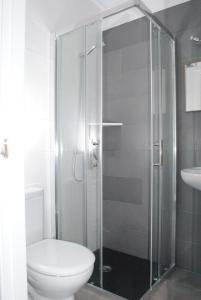 a bathroom with a toilet and a glass shower at Hostal Paris Ciutadella in Ciutadella