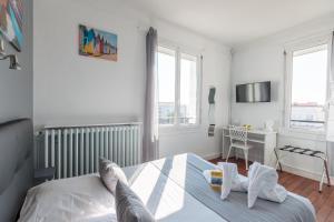 a bedroom with a bed and a desk and windows at Crystal Hotel in Royan