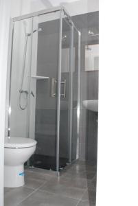 a bathroom with a shower with a toilet and a sink at Hostal Paris Ciutadella in Ciutadella