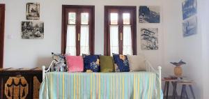 a room with a bed with colorful pillows on it at Sea breeze in the Aegean Sea in Agios Ioannis Pelio