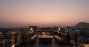 a balcony with couches and a table with a view at Aura Boutique Hotel in Udaipur