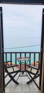 a table on a balcony with a view of the ocean at Sea breeze in the Aegean Sea in Agios Ioannis Pelio