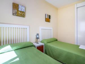 2 camas en una habitación con sábanas verdes en Apartamento 337, en Marbella