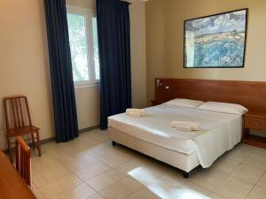 Ένα ή περισσότερα κρεβάτια σε δωμάτιο στο Hotel Adriatico