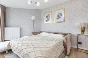 een slaapkamer met een groot bed en twee foto's aan de muur bij Premium Apartament PINEA Pobierowo in Pobierowo