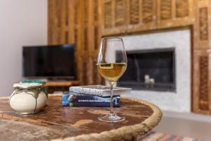 a glass of wine sitting on top of a table at Thalassa Luxury Villa in Ialyssos +26 photos