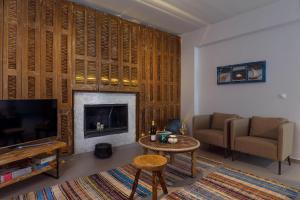 a living room with a fireplace and a television at Thalassa Luxury Villa in Ialyssos