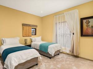 a bedroom with two beds and a window at 295 on Ingwenya in Dullstroom