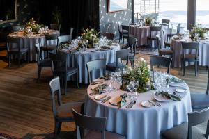 a dining room with tables and chairs with white tablecloths at Apvalaus Stalo Klubas Gastro & SPA Hotel in Trakai