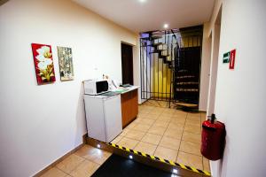 a small kitchen with a microwave and a staircase at Tanie Noclegi 2 in Kielce