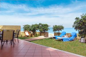 a person laying in blue chairs on the grass at Nikogroup By the Sea 2 in Polychrono