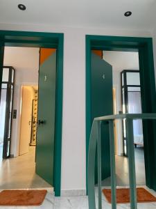 zwei grüne Türen in einem Zimmer mit einer Treppe in der Unterkunft IOANNINA SUITES in Ioannina