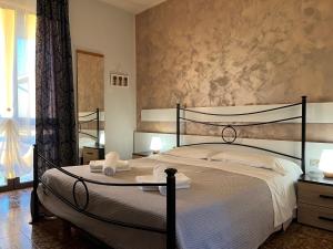 - une chambre avec un grand lit et des serviettes dans l'établissement Hotel Renata, à Lazise