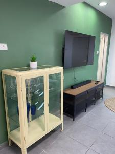 un centro de entretenimiento con TV en una pared verde en מתחם החוף, en Tel Aviv