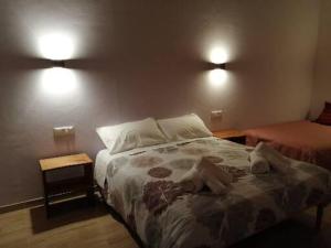 a bedroom with a bed and two lights on the wall at Agriturismo NONNU LUI` in Amandola