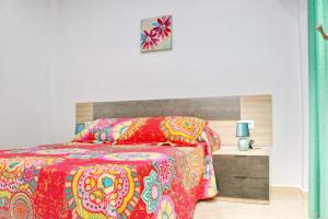 1 dormitorio con 1 cama con edredón rojo en Apartamento San Ignacio Loyola, en Conil de la Frontera