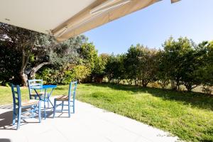 uma mesa e cadeiras num pátio com relvado em Athenian Riviera Maisonette, Varkiza, 7min walk from Beach Park em Vári