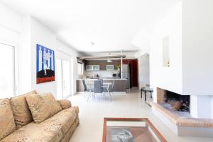 uma sala de estar com um sofá e uma lareira em Athenian Riviera Maisonette, Varkiza, 7min walk from Beach Park em Vári