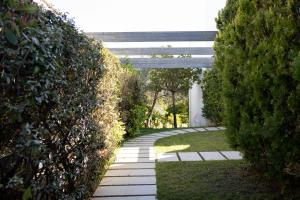 a walkway between two hedge hedges in a garden at Athenian Riviera Maisonette, Varkiza, 7min walk from Beach Park in Vari
