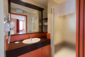 a bathroom with a sink and a mirror at La Couronne in Jougne