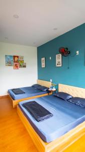 Duas camas num quarto com paredes azuis em Toru Homestay em Quy Nhon