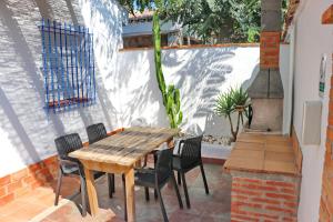 una mesa de madera y sillas en un patio en Bungalow La Roa I, en Conil de la Frontera