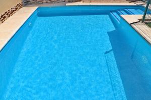 una gran piscina azul con agua azul en Bungalow Curro Pareja 97, en Conil de la Frontera