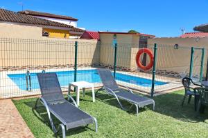 eine Gruppe von Stühlen neben einem Pool in der Unterkunft Bungalow Curro Pareja 97 in Conil de la Frontera