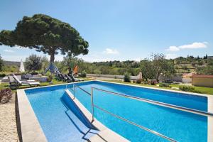 a large swimming pool with blue water at Villa Rodrigues Apartment ii in Boliqueime